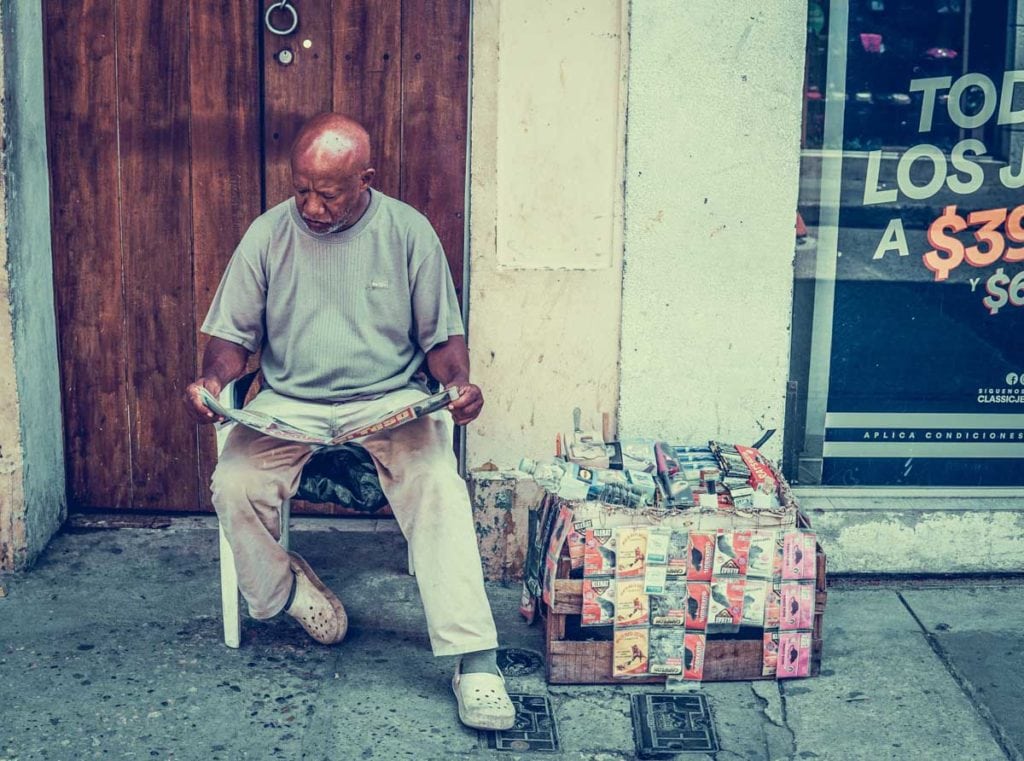 Homem a vender jornais na rua na Colômbia